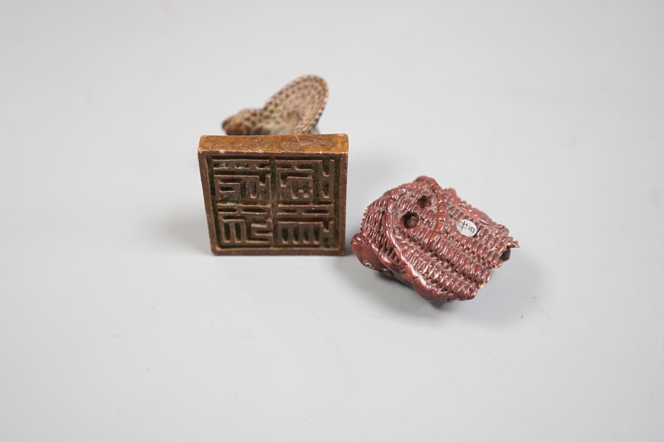 A Chinese bronze 'cobra' seal and a Japanese carved wood netsuke with signed mother of pearl tablet to underside. Seal 4cm tall